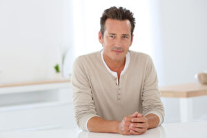 Image of a man leaning on a counter and smiling