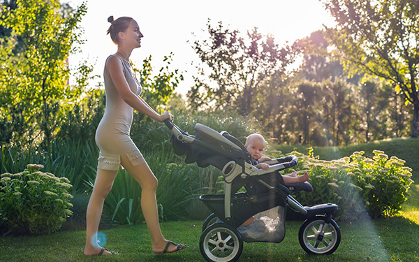Image of a mom walking in her child in a stroller.