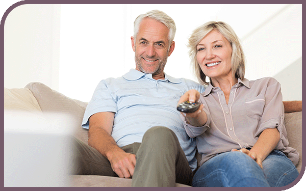 older man and woman sitting on a couch