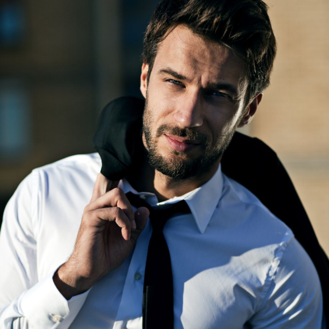 A confident man wearing a suit walking.