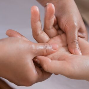 a person massaging a hand while the fingers bend