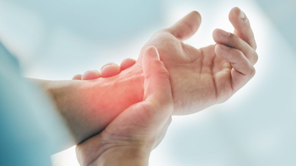 Person grabbing an inflamed wrist.