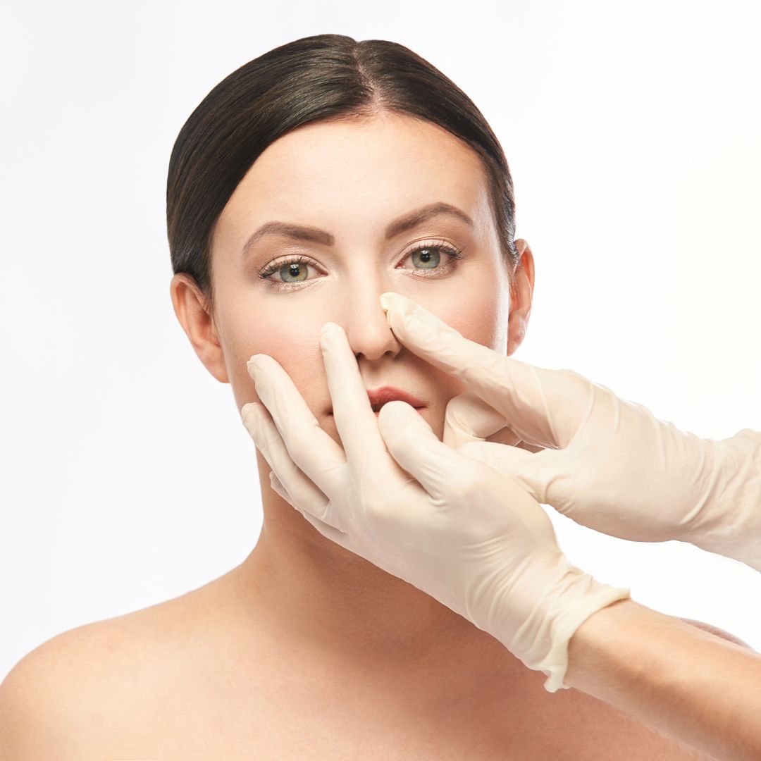 A women with a set of hands on her nose