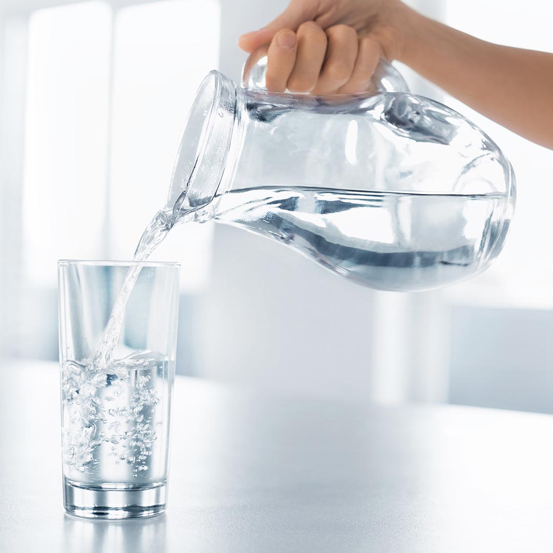 woman pouring a glass of water