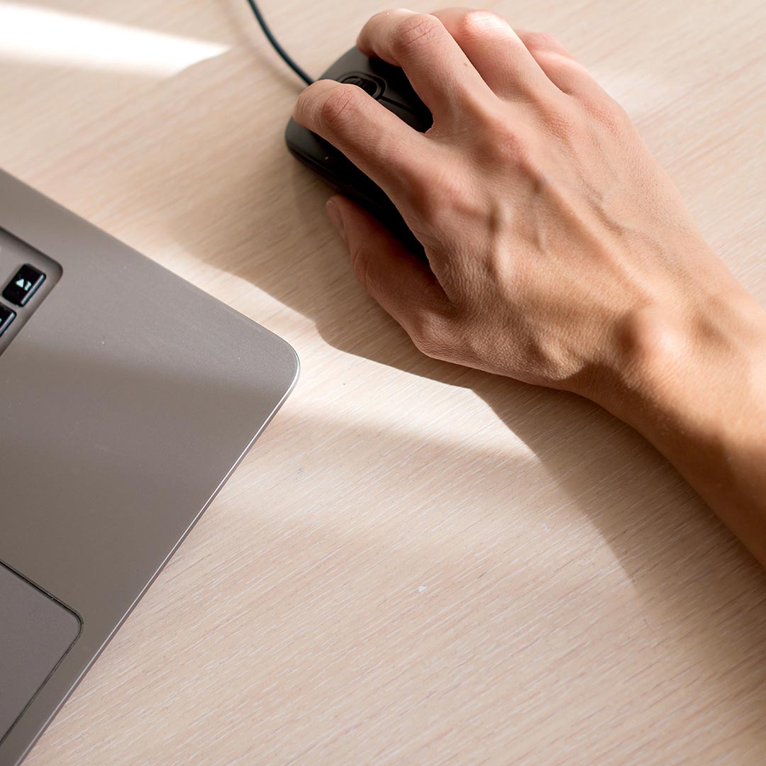 hand with a ganglion cyst on it using a computer mouse