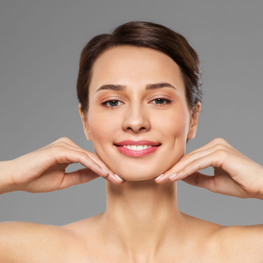 a woman smiling with her fingers under her chin