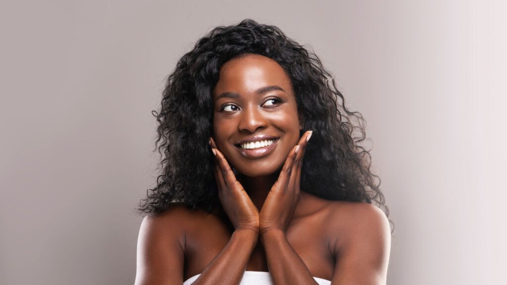 a woman holding her cheeks and smiling