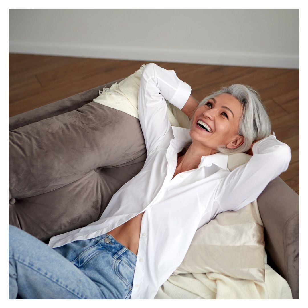 mature woman laying on sofa smiling