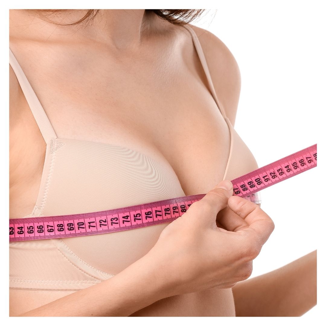 a woman measuring her breast size with a tape measurer