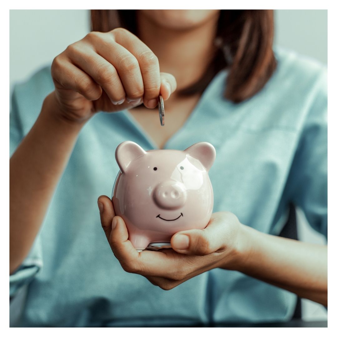 a woman adding money to a piggy bank