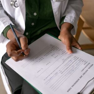 doctor writes on medical history form