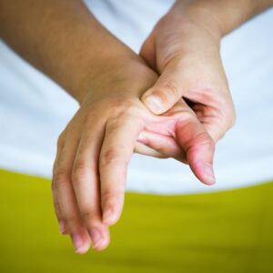 Man massaging painful thumb joint