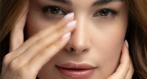 close up of a woman's face with her hand on her nose